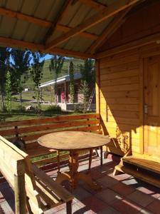 a wooden table and benches in a cabin at Гостевой дом Темирлан in Kegeti