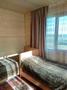 - une chambre avec 2 lits et une fenêtre dans l'établissement Гостевой дом Темирлан, à Kegeti