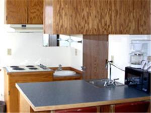 a kitchen with a black counter top and a microwave at Avenue Motel Wenatchee in Wenatchee