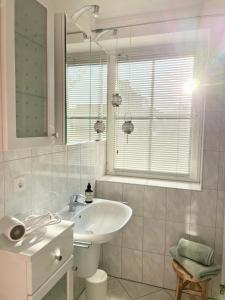 ein weißes Badezimmer mit einem Waschbecken und einem Spiegel in der Unterkunft Turmresidenz 6 KaMare - 300m zum Strand in Scharbeutz