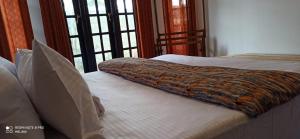 two beds in a room with windows at Heart of the Hill in Nuwara Eliya
