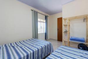 - une chambre avec 2 lits et une fenêtre dans l'établissement Sobrado da Vila, 1km Centro, ideal Trabalho e Passeio, à Morretes