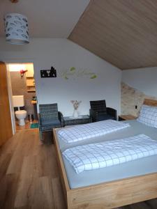 ein Schlafzimmer mit einem Bett und Stühlen in einem Zimmer in der Unterkunft Frühstückspension Lemberger in Dellach im Drautal