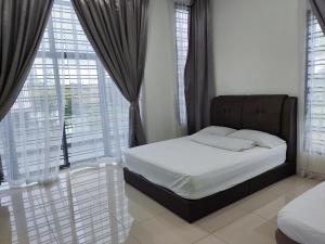 a bedroom with a bed and a large window at HK68 Desaru homestay in Kangkar Chemaran