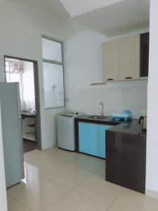 a kitchen with white walls and blue appliances at HK68 Desaru homestay in Kangkar Chemaran +17 photos