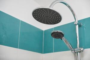 a shower head in a bathroom with blue tiles at La casa dei nonni in Paola +29 photos