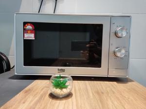 a person taking a picture of a microwave at HK68 Desaru homestay in Kangkar Chemaran