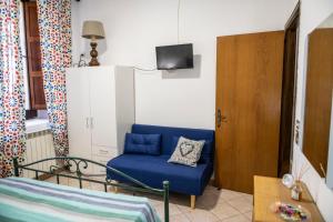 a living room with a blue couch and a tv at La casa dei nonni in Paola