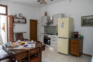a kitchen with a table and a refrigerator at La casa dei nonni in Paola