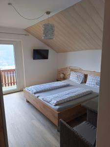 a bedroom with a large bed and a balcony at Frühstückspension Lemberger in Dellach im Drautal