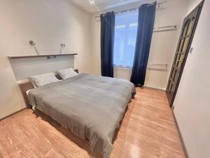 a bedroom with a bed and a large window at 2-room apartment in the city center in Poznań