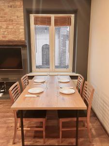 a wooden table with chairs and a large window at 2-room apartment in the city center in Poznań