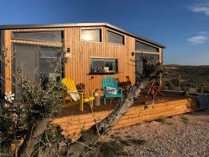 a cabin with a deck with chairs on it at Zeytiny l Tiny Houses & Farm l Çeşme in Cesme
