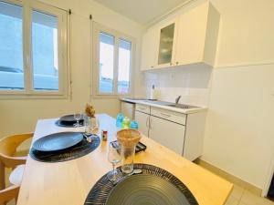 a kitchen with a table with glasses on it at Le Joly Cocon-Proche mer-wifi-fibre in Saint-Nazaire