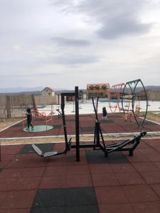 a park with a playground with two swings at Sunset vila sa bazenom in Lebane