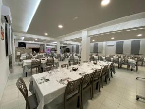 une salle à manger avec des tables et des chaises blanches dans l'établissement Santoianni, à San Martino in Pensilis