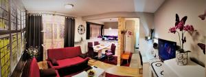uma sala de estar com um sofá vermelho e uma mesa em Apartmani Peyton em Slavonski Brod