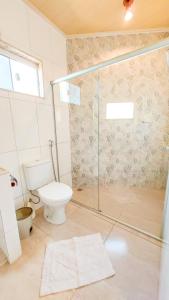 a bathroom with a toilet and a glass shower at Bangalôs Canto da Coruja in Sao Jorge