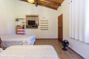 a room with two beds and a television in it at Recanto do sossego!! in Morretes