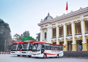 twee bussen geparkeerd voor een gebouw bij Nhat Mai Hotel in Cat Ba