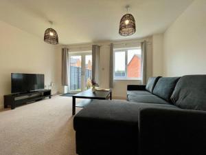 a living room with a couch and a flat screen tv at Big Modern House - 15min to NEC - Sleeps 10 in Birmingham