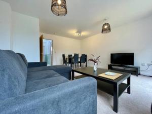 Big Modern House - 15min to NEC - Sleeps 10 في برمنغهام: غرفة معيشة مع أريكة زرقاء وطاولة