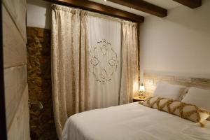 a bedroom with a white bed and a curtain at Can Senio 1 in Tossa de Mar
