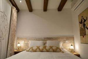 1 dormitorio con 1 cama blanca grande y 2 lámparas en Can Senio 1 en Tossa de Mar
