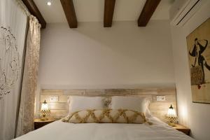 a bedroom with a large white bed with two lamps at Can Senio 1 in Tossa de Mar +26 photos