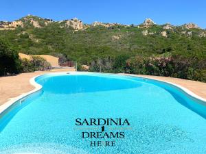uma piscina com um sinal que lê santa ana sonhos que ele ne em Villa Flavia con piscina em Costa Paradiso