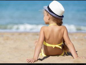 ラ・カラ・デ・ミハスにあるMI CAPRICHO BEACHFRONT- P300 - Apartment with sea viewの砂浜に腰掛けている少女