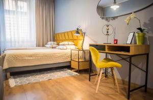 um quarto com uma cama, uma secretária e uma cadeira em Apartament CCH - Biskupia em Chełmno