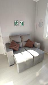 uma sala de estar com um sofá e duas fotografias na parede em Cidade Baixa Apart Studio Encantador em Porto Alegre