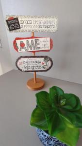 a sign and a plant in a room at Cidade Baixa Apart Studio Encantador in Porto Alegre