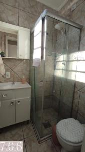 uma casa de banho com um chuveiro, um WC e um lavatório. em Cidade Baixa Apart Studio Encantador em Porto Alegre