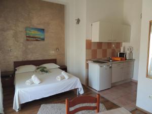 a bedroom with a bed and a small kitchen at Apartments Nika in Podstrana
