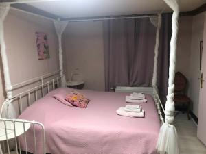 - une chambre avec un lit rose à baldaquin dans l'établissement Les Lumerettes - Dohan, à Bouillon