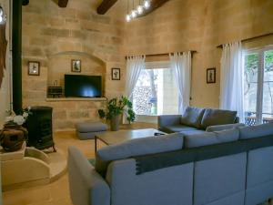 a living room with a couch and a tv at Il Gnejna in Xagħra