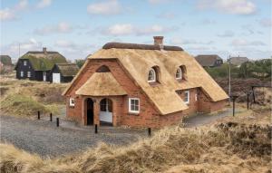 a model of a house with a thatched roof at Cozy Home In Blvand With Sauna in Blåvand