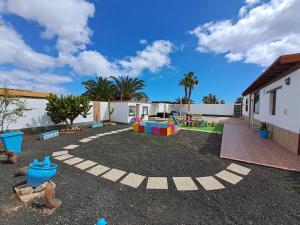 patio trasero con parque infantil y zona de juegos en Villa Experience Heated Salty Water Pool, en Caleta de Fuste