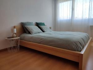 un letto in una camera bianca con una grande finestra di Apartment near airport & citycenter Free Parking a Lisbona