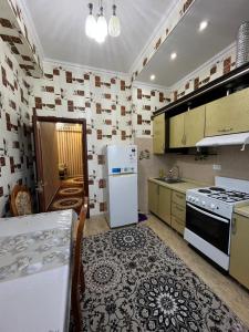 a kitchen with a refrigerator and a table in it at Karabolo in Dushanbe