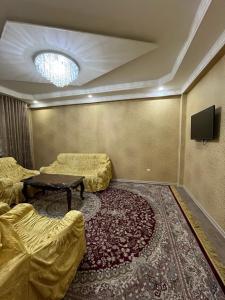 Habitación con camas, mesa y TV. en Karabolo, en Dushanbe