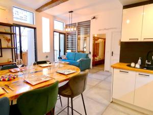 a kitchen and living room with a wooden table and chairs at The Ginkgo Collioure : Amazing Private Jacuzzi built in Rock, 20m from the Beach, A/C, WiFi, Patio... in Collioure
