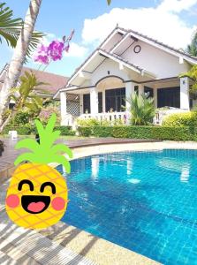 House in Ban Phe, Thailand في رايونغ: بيت فيه لافته اناناس بجانب مسبح