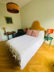 1 dormitorio con 1 cama blanca grande con almohadas rosas en Ben A'an House, en Callander