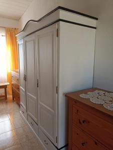 een slaapkamer met een grote witte kast en een tafel bij Casa da Paz-Martinchel in Casal do Rei