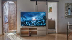 a living room with a flat screen tv on a stand at CASA CUADERNA a 150 metros de la playa in Playa Honda