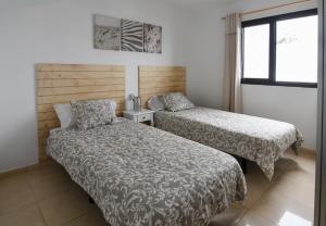 a bedroom with two beds and a window at CASA CUADERNA a 150 metros de la playa in Playa Honda
