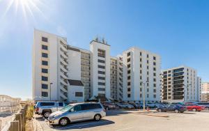 a parking lot with cars parked in front of tall buildings at Island Winds East by Brett Robinson Vacations in Gulf Shores